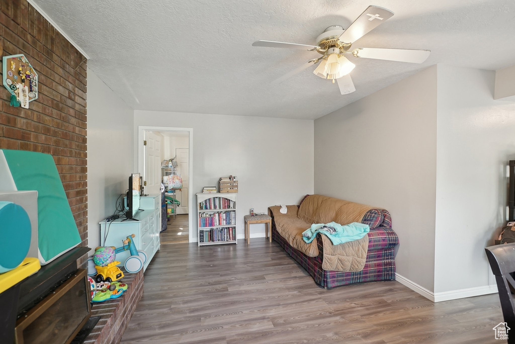 Sitting room featuring a textured ceiling, wood-type flooring, and ceiling fan