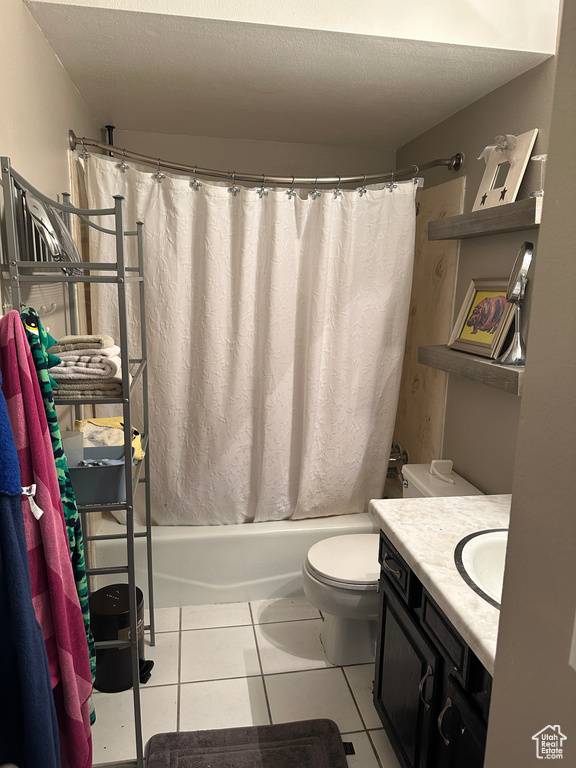 Full bathroom featuring vanity, shower / bath combination with curtain, toilet, a textured ceiling, and tile patterned flooring