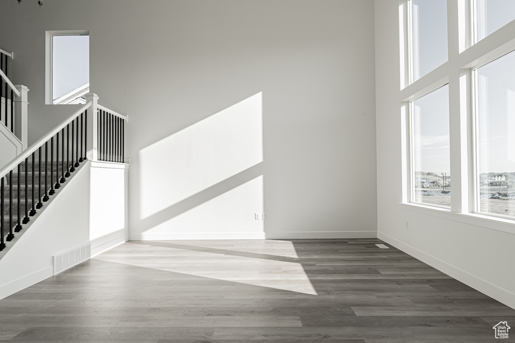 Interior space with dark hardwood / wood-style flooring and a high ceiling