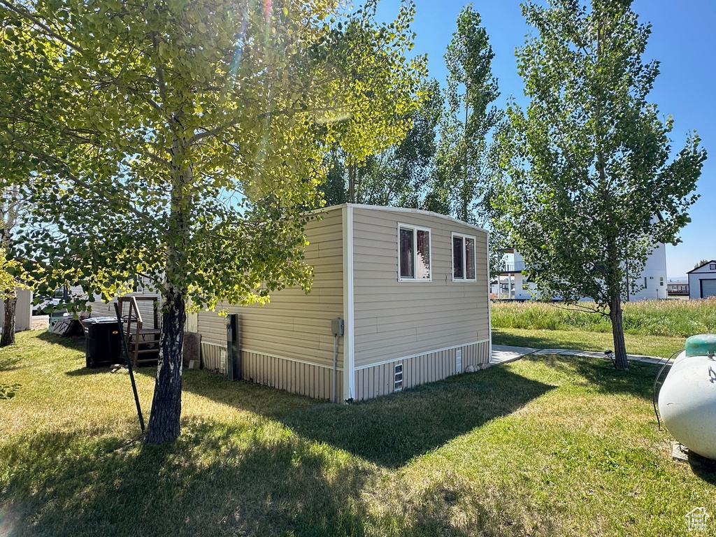 View of side of home featuring a yard