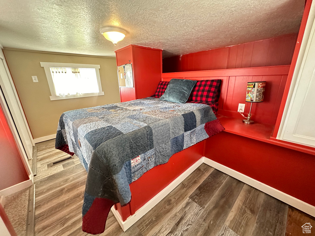 Bedroom with wood-type flooring and a textured ceiling