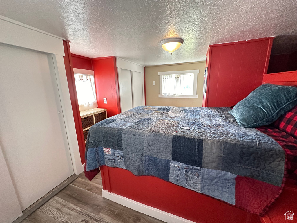 Bedroom featuring a closet, a textured ceiling, and hardwood / wood-style floors