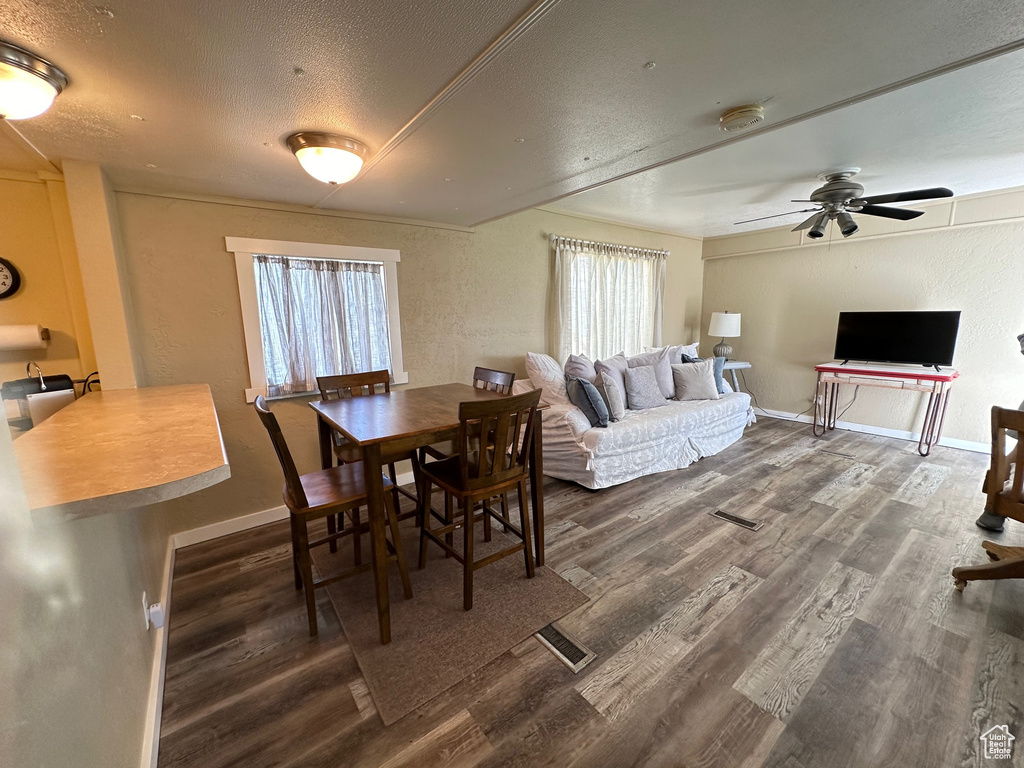 Dining room with a textured ceiling, hardwood / wood-style floors, and ceiling fan