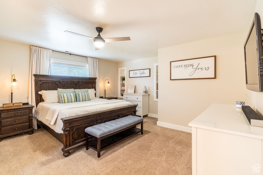 Carpeted bedroom featuring ceiling fan