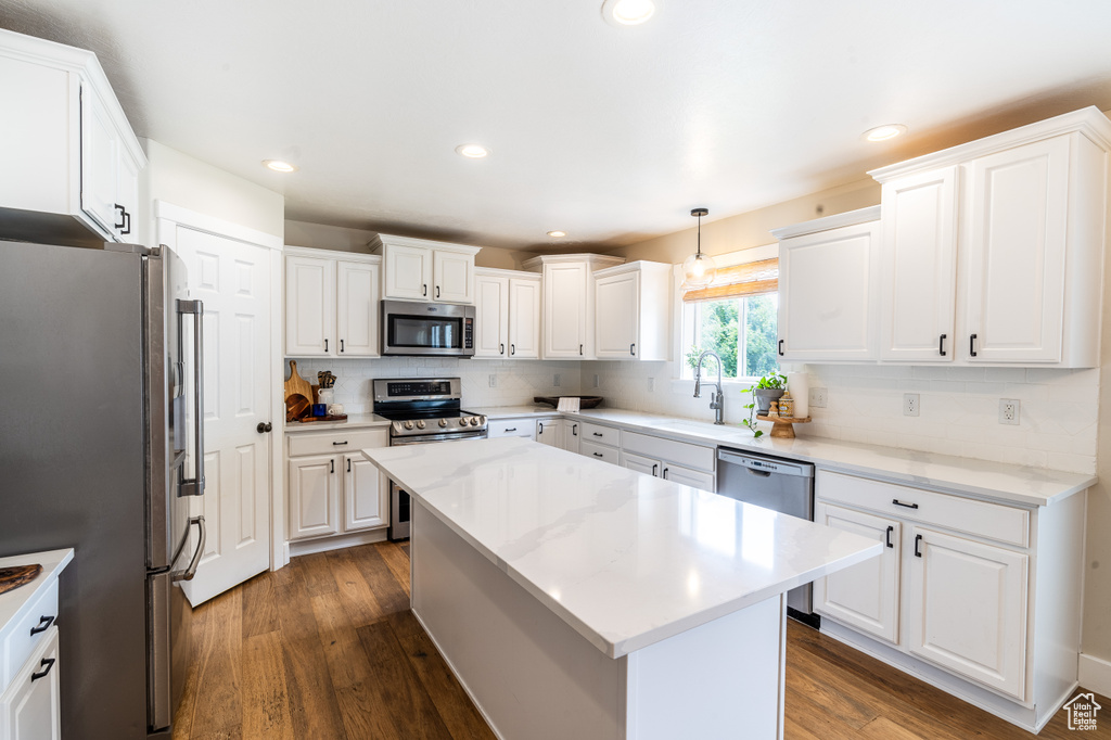 Kitchen with dark wood-type flooring, white cabinets, and stainless steel appliances