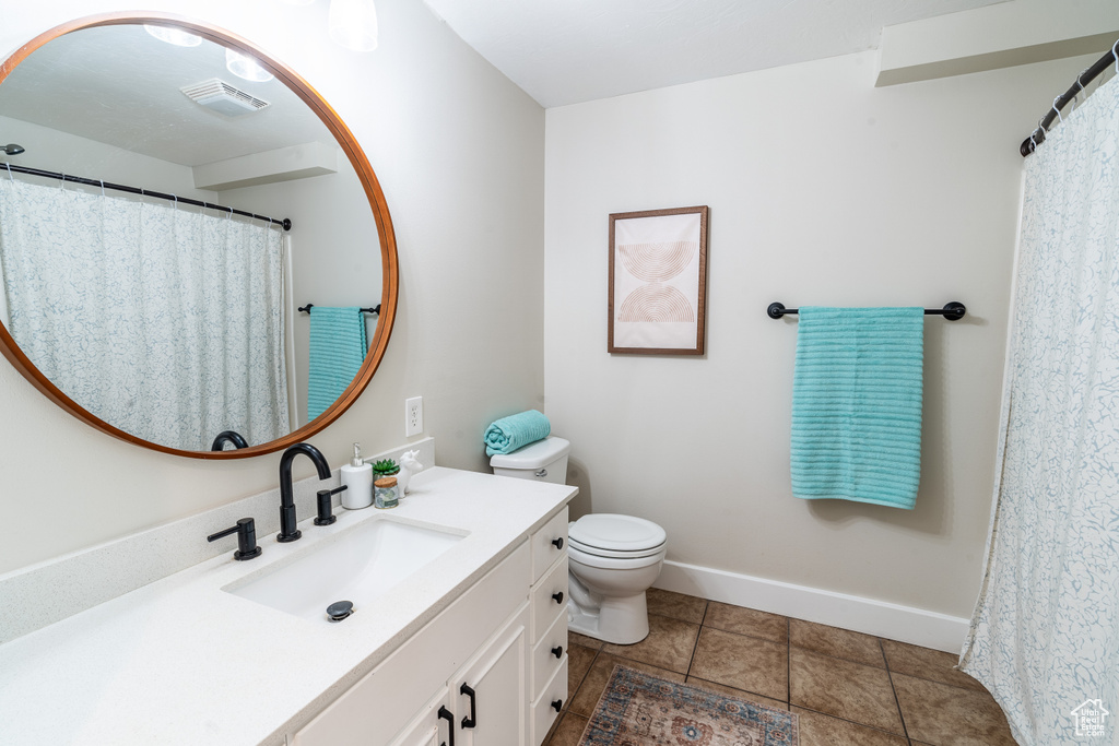 Bathroom featuring tile patterned flooring, toilet, and vanity