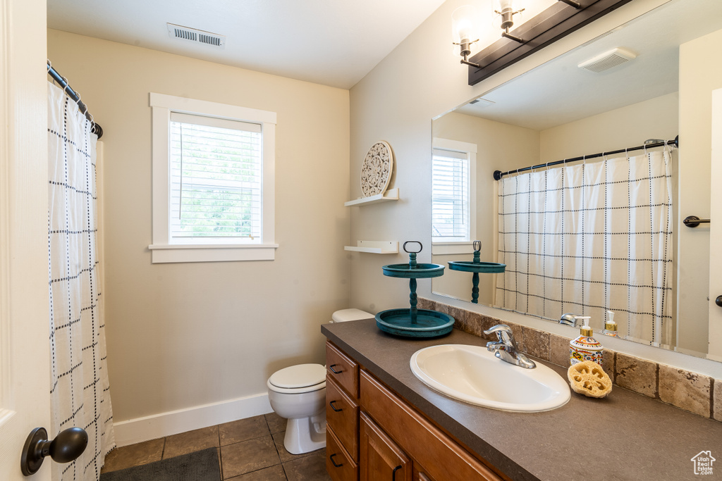 Bathroom featuring tile patterned floors, toilet, and vanity