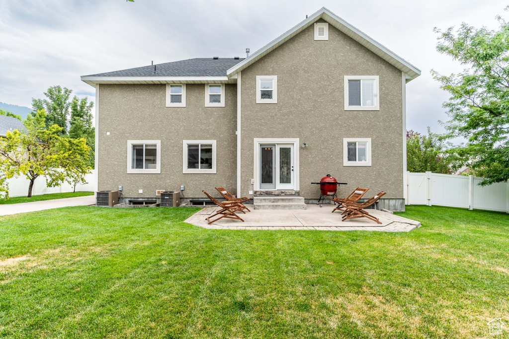 Rear view of house featuring a patio and a yard