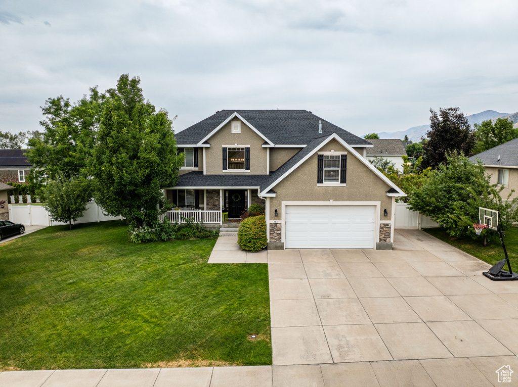 View of front of home with a garage and a front lawn