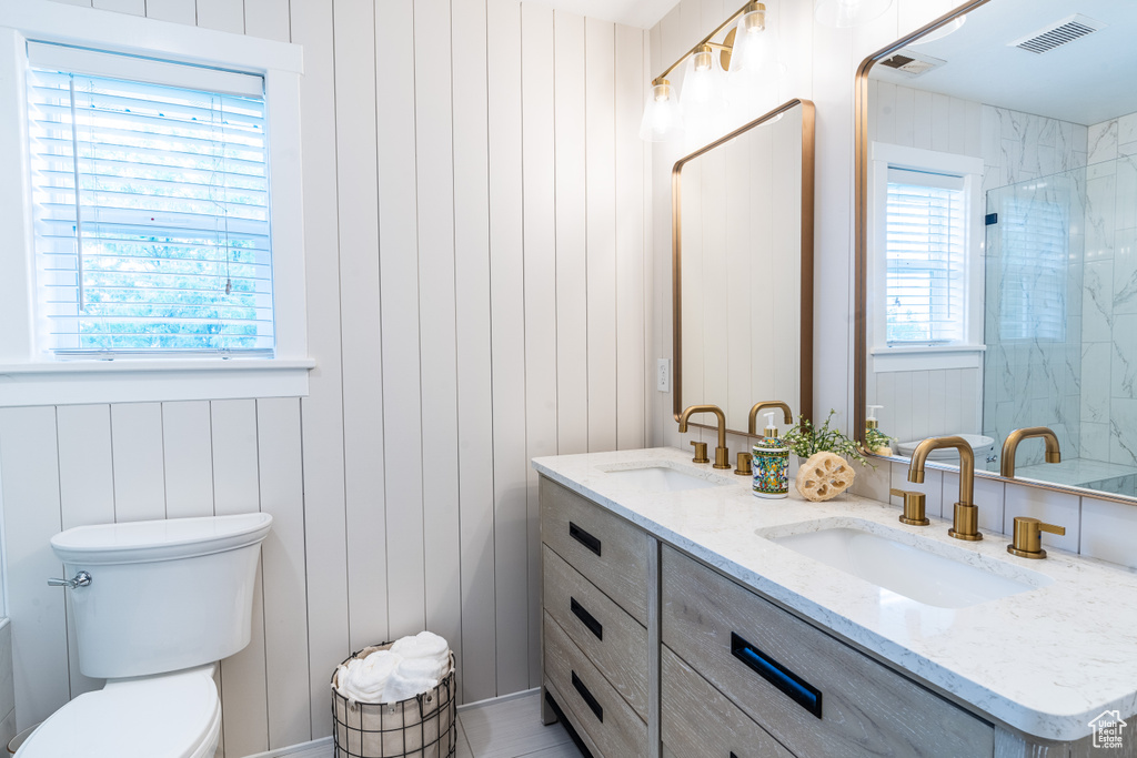 Bathroom featuring vanity, toilet, and a wealth of natural light