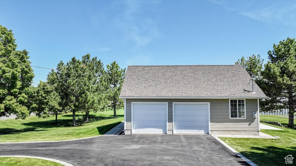 Exterior space featuring a garage and a lawn