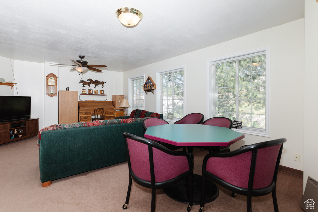 Dining room featuring light colored carpet and ceiling fan