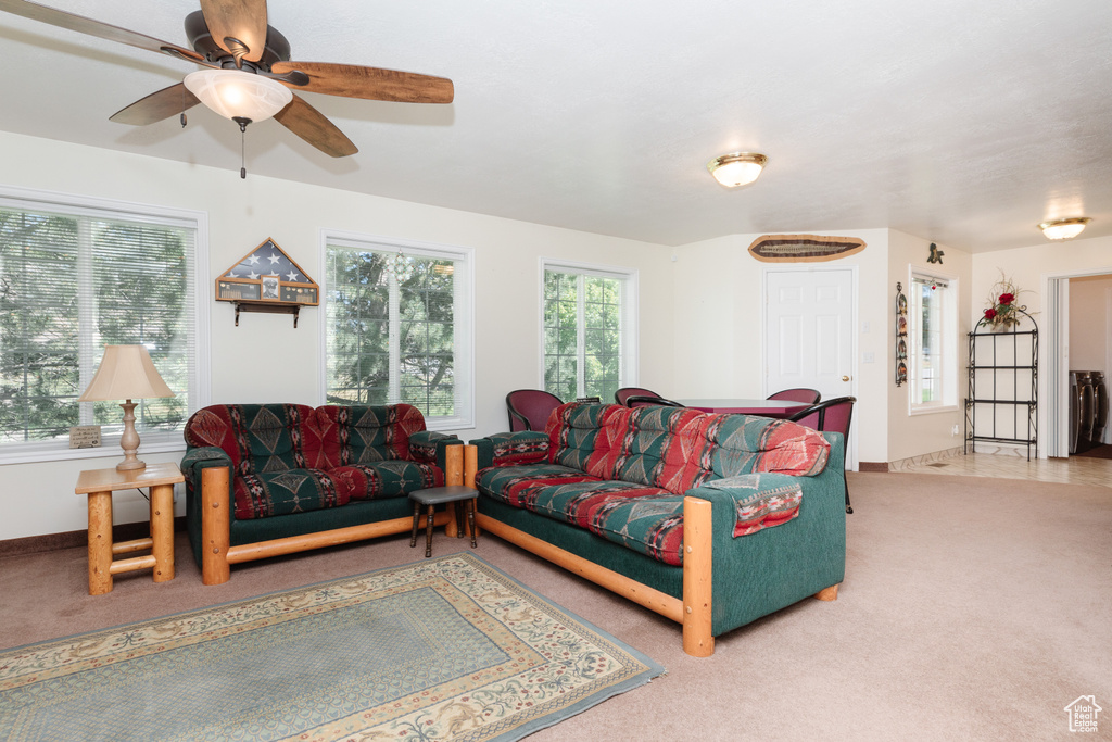 Carpeted living room featuring ceiling fan