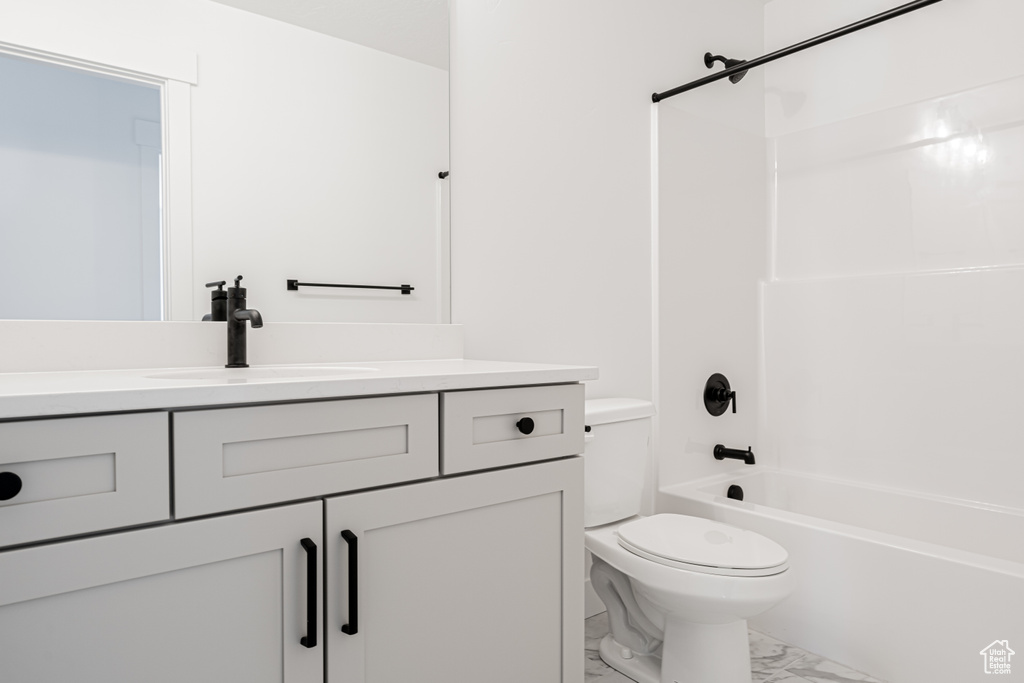 Full bathroom featuring vanity, shower / bath combination, and toilet