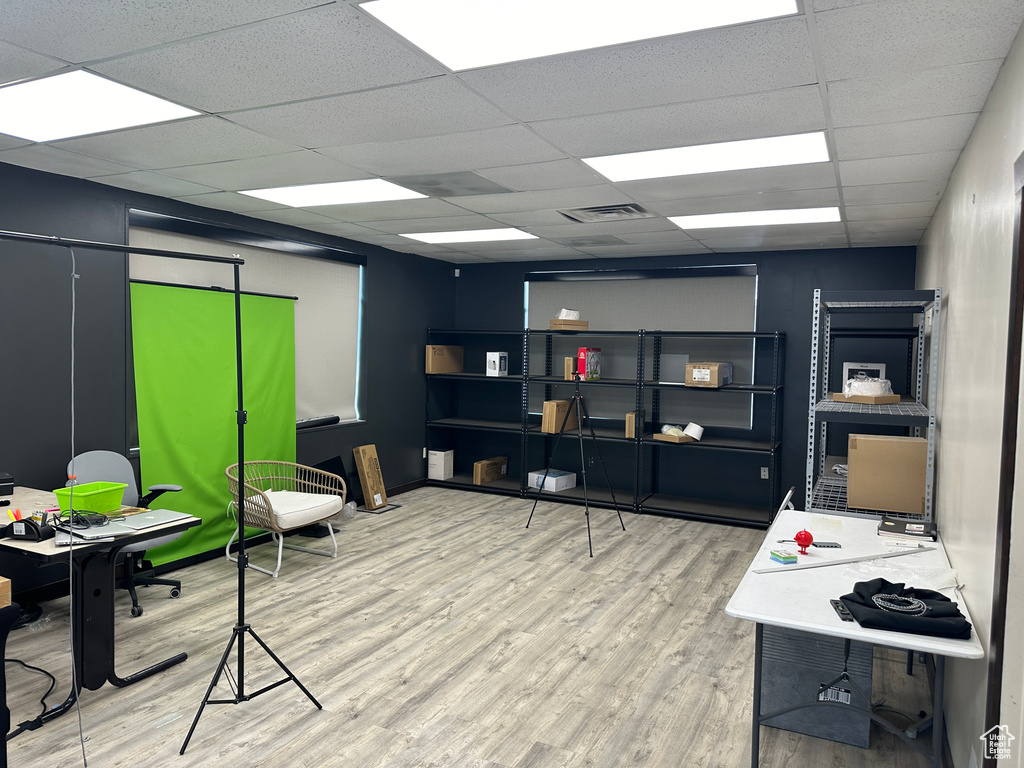 Office space with a paneled ceiling and hardwood / wood-style floors