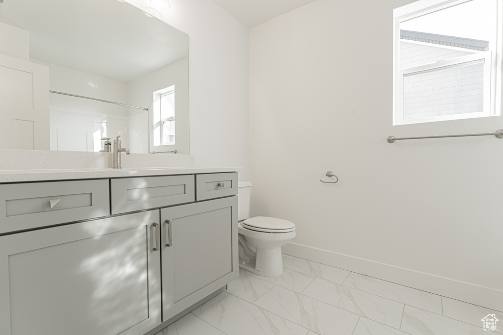 Bathroom with a shower, vanity, and toilet