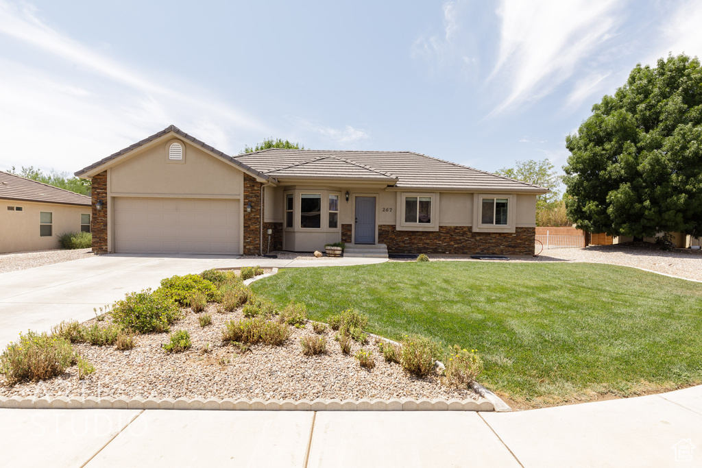 View of front of house with a garage and a front lawn