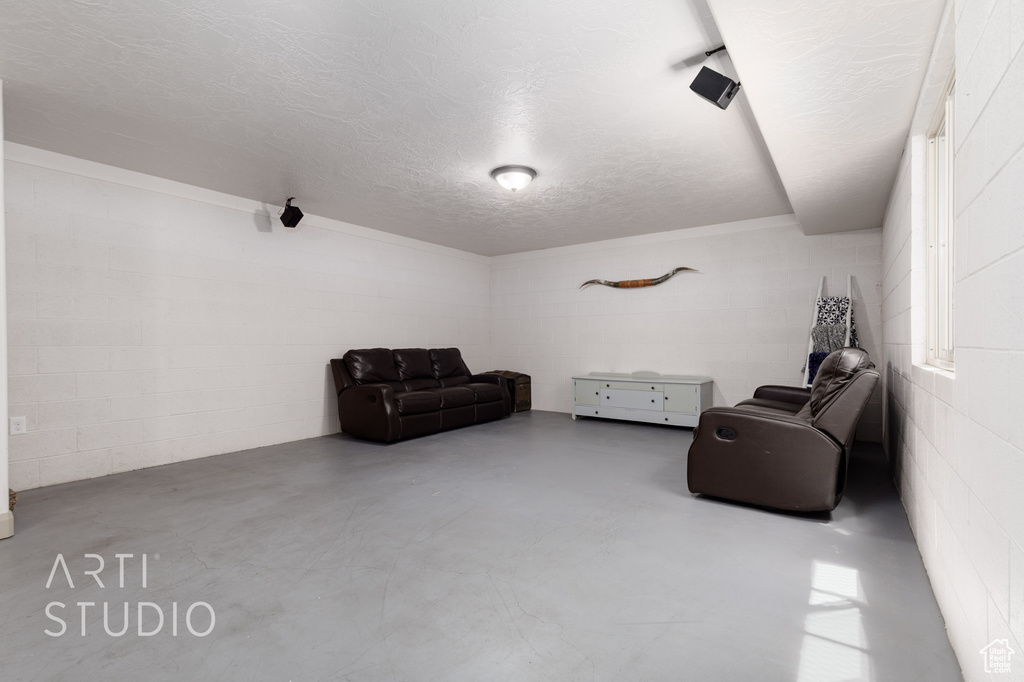 Living area with a textured ceiling and concrete flooring