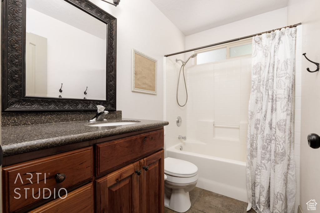 Full bathroom with tile patterned floors, vanity, shower / tub combo, and toilet