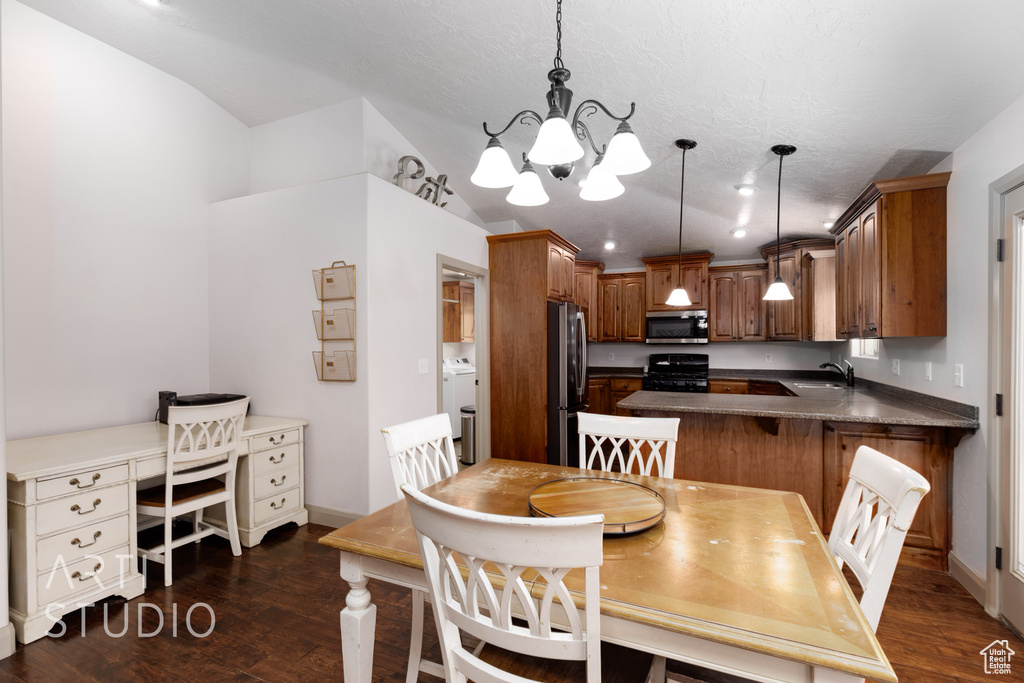 Dining area featuring sink, a chandelier, dark hardwood / wood-style floors, and washer and dryer