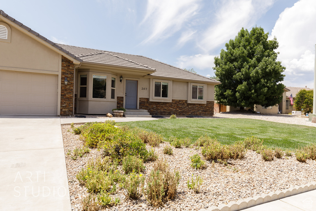 Single story home with a garage and a front yard