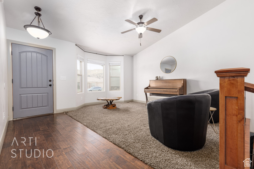 Entrance foyer with ceiling fan, vaulted ceiling, and dark wood-type flooring