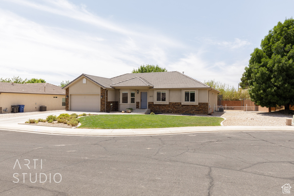 Ranch-style house featuring a garage and a front lawn