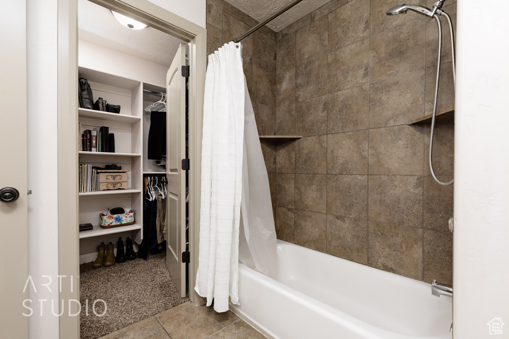 Bathroom with tile patterned floors and shower / tub combo with curtain