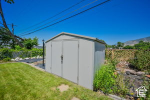 View of outdoor structure featuring a lawn