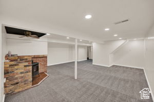 Basement with a wood stove and carpet floors