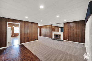 Unfurnished living room featuring wooden walls