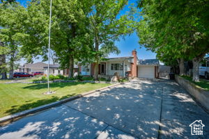 Ranch-style home featuring a garage and a front lawn