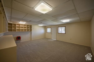 Basement with carpet floors and a paneled ceiling