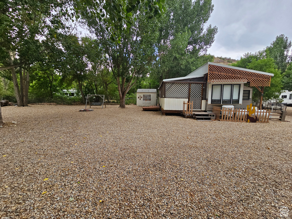 View of yard with a deck and an outdoor structure