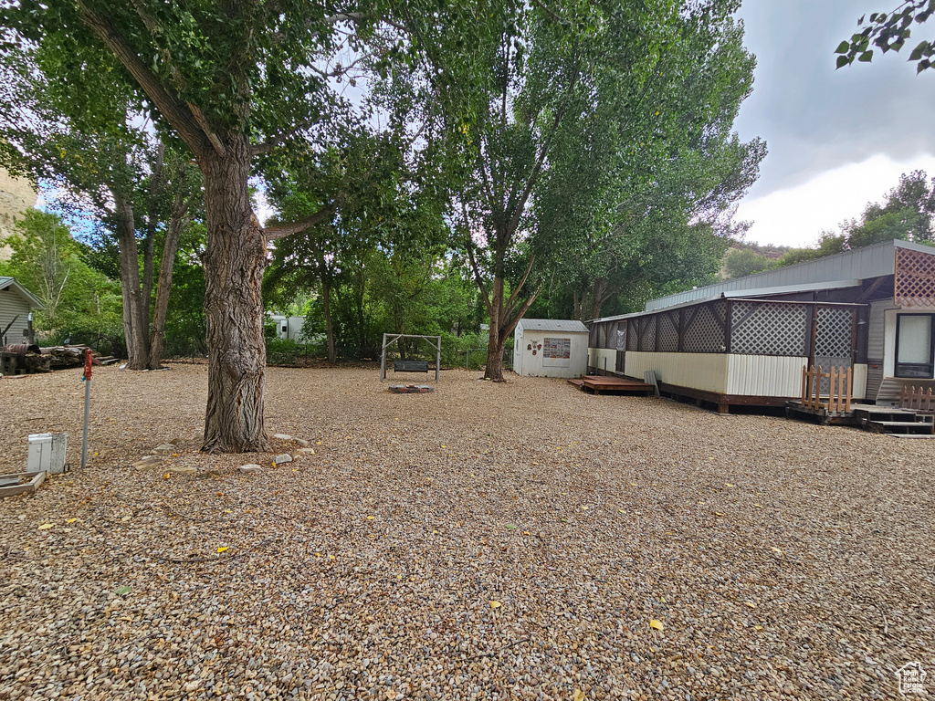 View of yard with a shed and a wooden deck