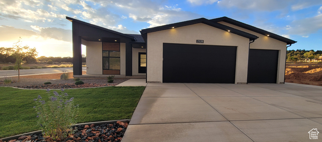 Contemporary house featuring a garage and a yard