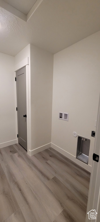 Clothes washing area with light wood-type flooring and hookup for a washing machine