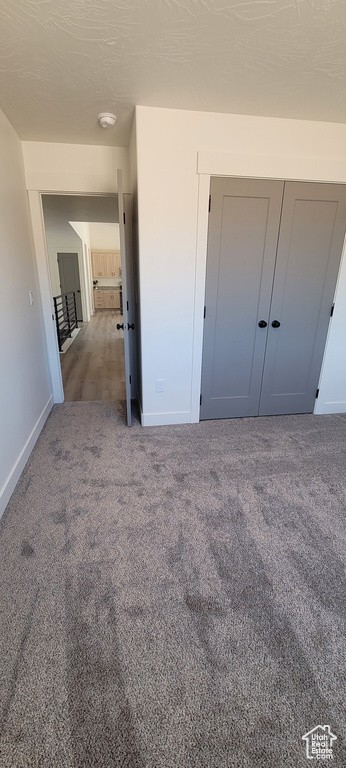 Unfurnished bedroom featuring a closet and carpet flooring