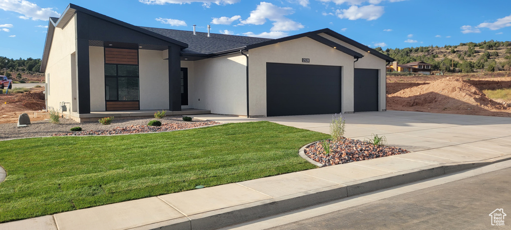 Modern home with a garage and a front lawn