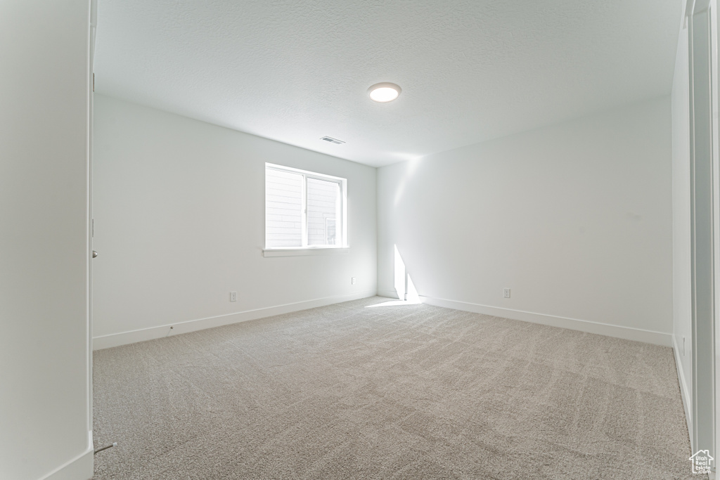Carpeted empty room featuring baseboards