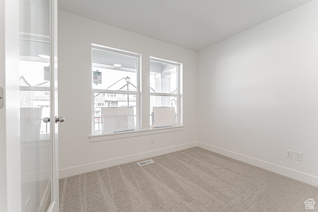Carpeted empty room featuring baseboards