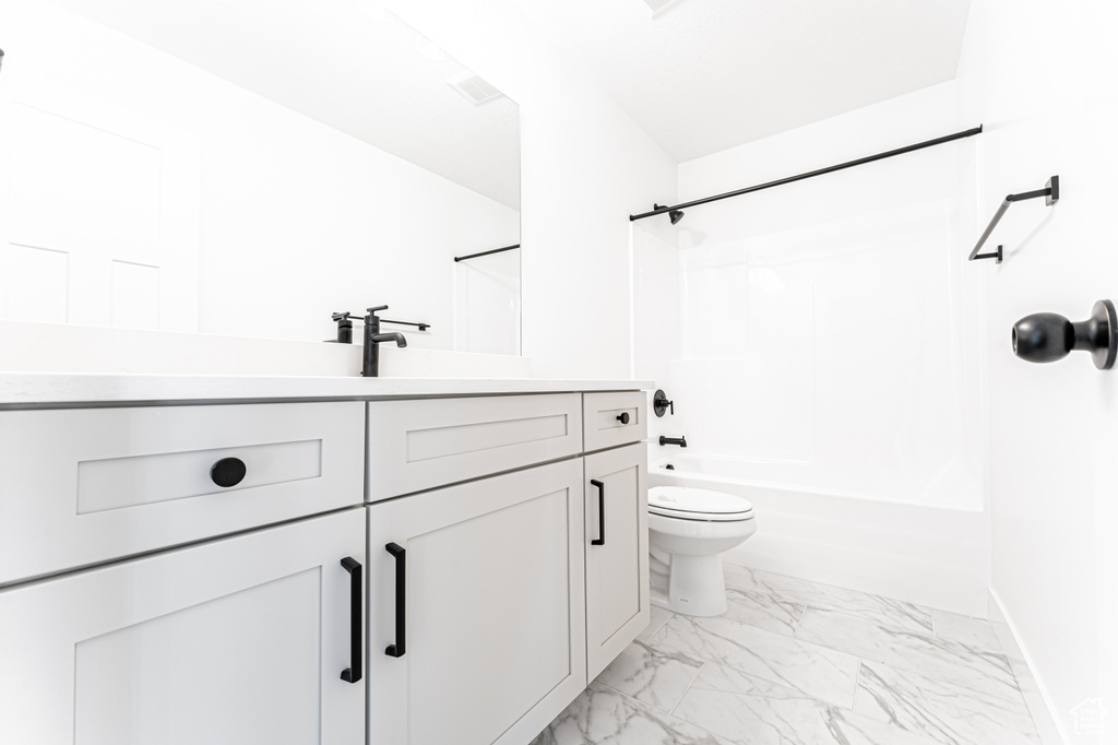 Full bathroom featuring vanity, baseboards, shower / tub combination, toilet, and marble finish floor