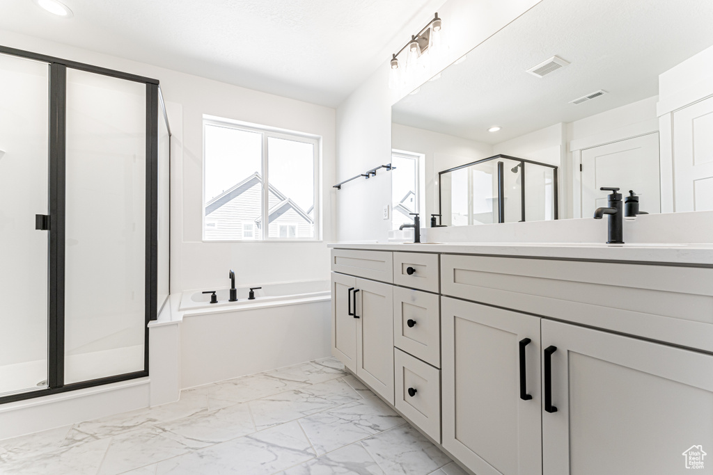 Full bath featuring a shower stall, visible vents, marble finish floor, and double vanity