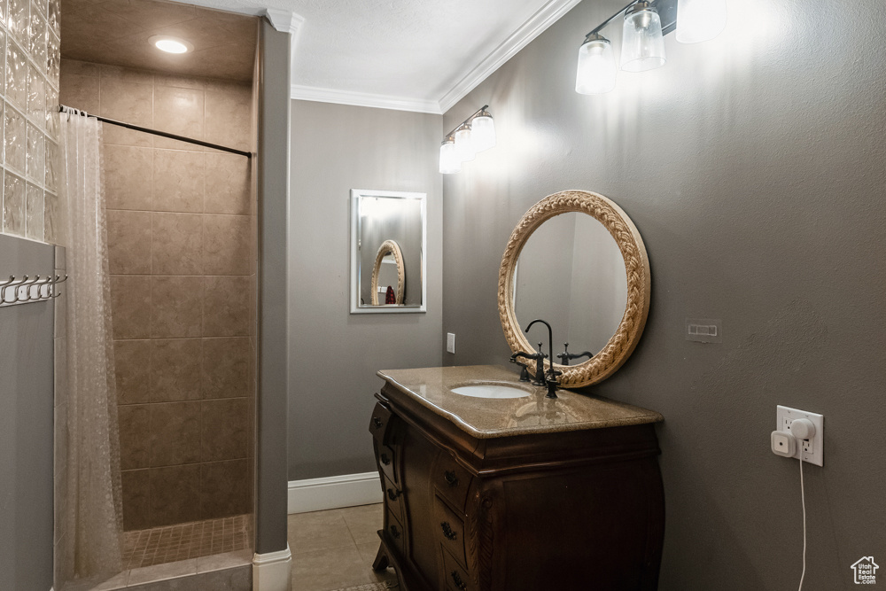 Bathroom with tile patterned flooring, curtained shower, crown molding, and vanity