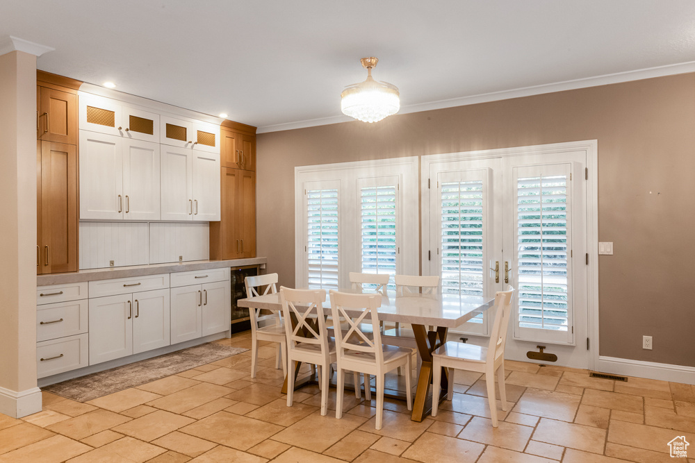 Dining room featuring light tile patterned floors and ornamental molding