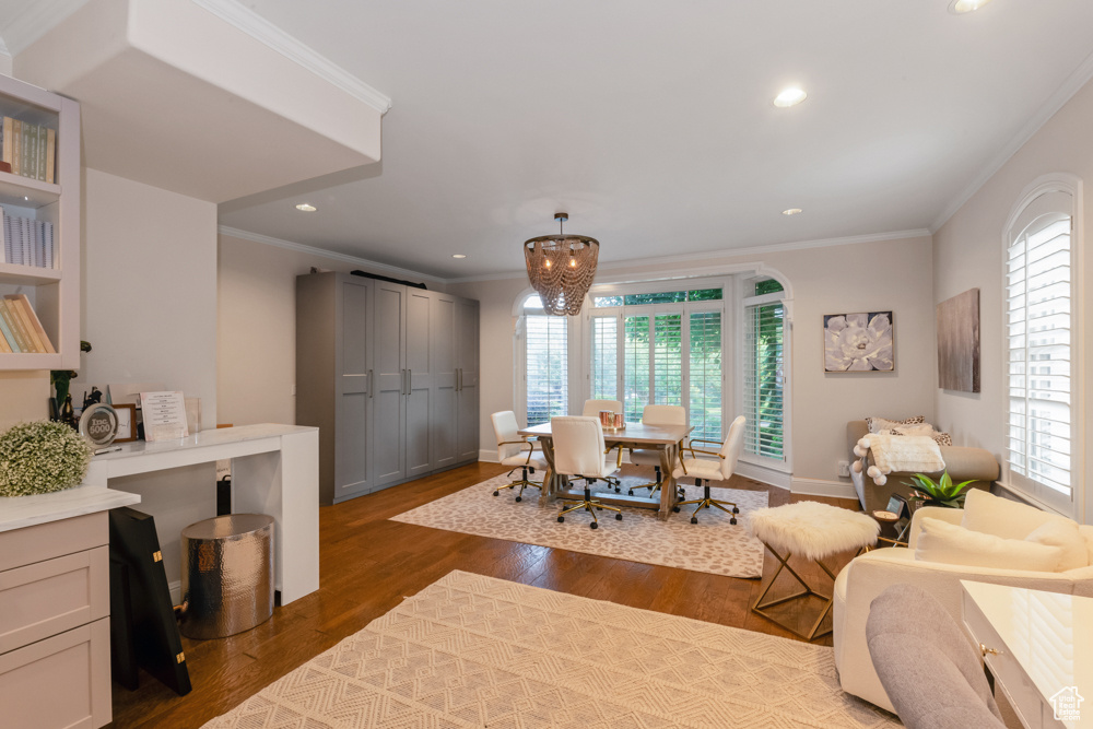 Living room with a healthy amount of sunlight, crown molding, and dark hardwood / wood-style floors