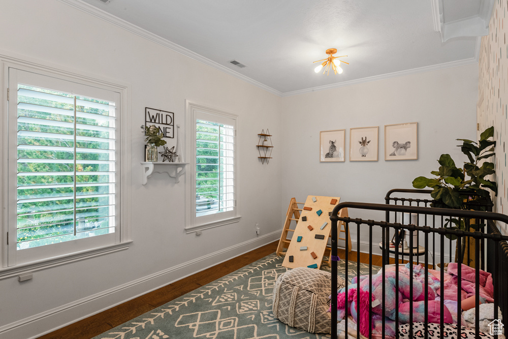 Bedroom with crown molding and hardwood / wood-style floors