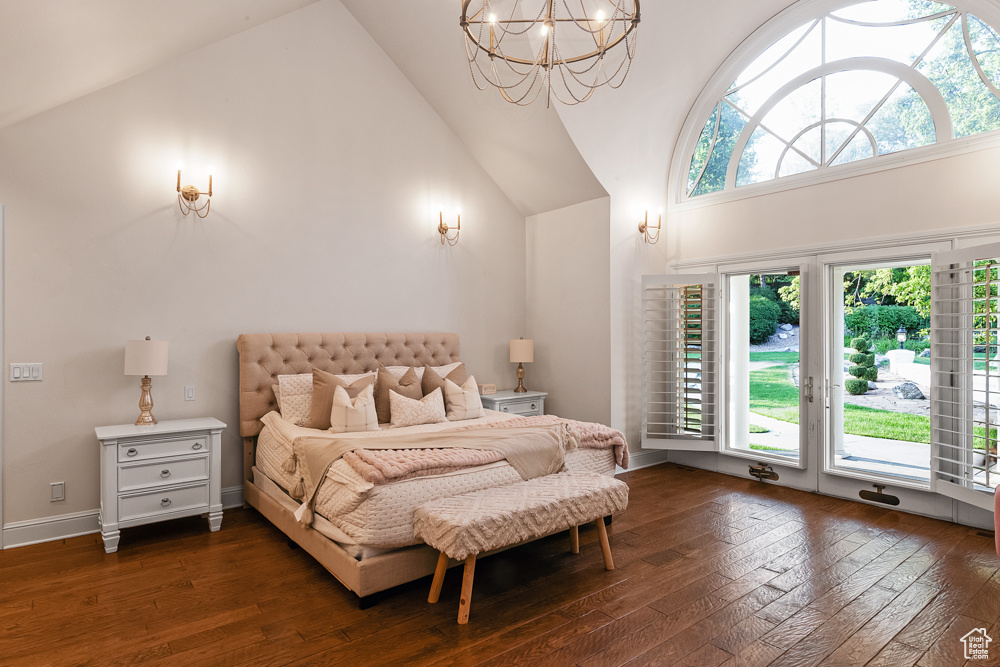 Bedroom featuring dark wood-type flooring, access to outside, and high vaulted ceiling