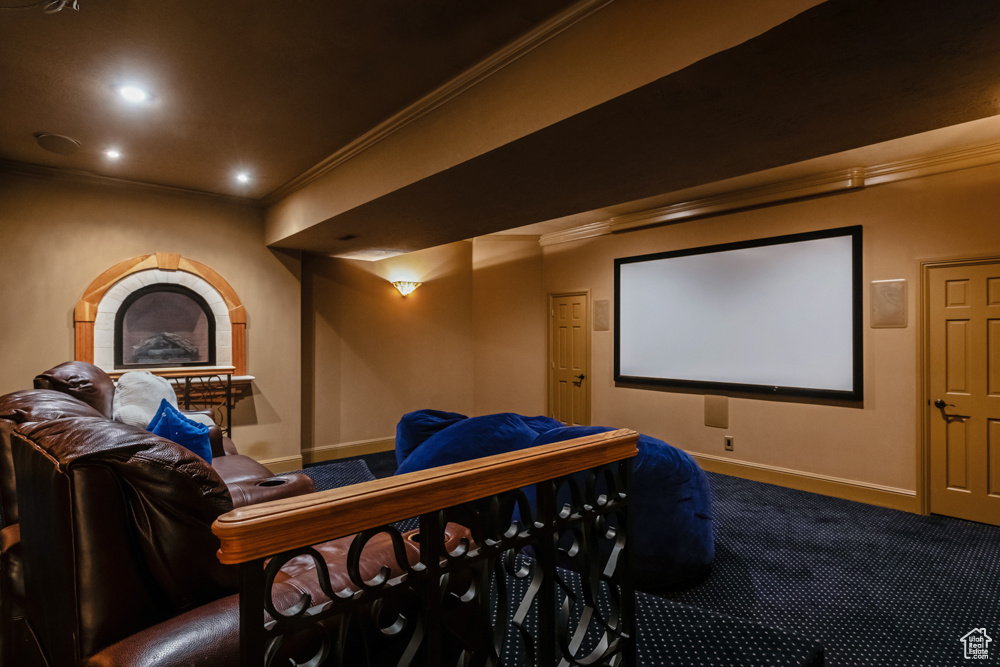 Carpeted home theater with crown molding