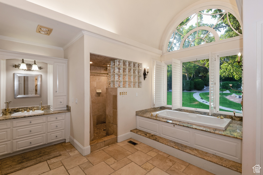 Bathroom featuring vanity, crown molding, tile patterned floors, and separate shower and tub